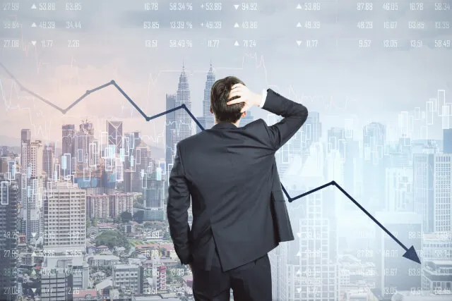 Manager reviewing declining revenue chart with city skyline in background
